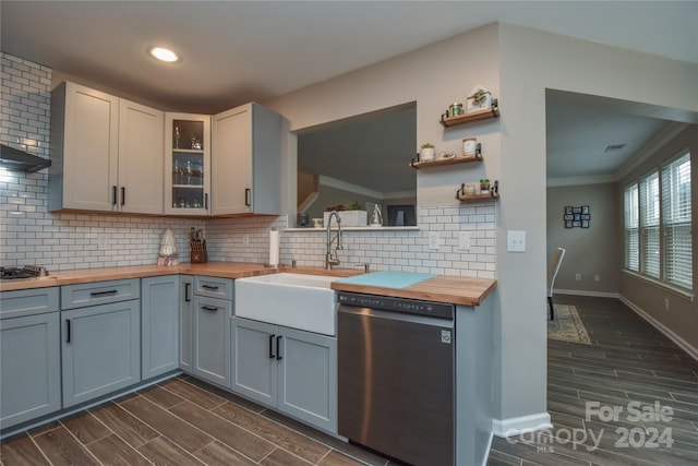 kitchen featuring dark hardwood / wood-style flooring, tasteful backsplash, ornamental molding, stainless steel appliances, and butcher block countertops