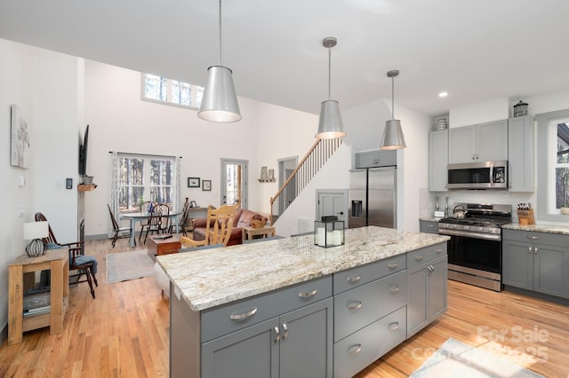 kitchen featuring gray cabinets, pendant lighting, and stainless steel appliances