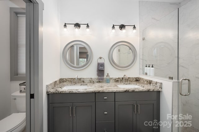 bathroom featuring an enclosed shower, vanity, and toilet