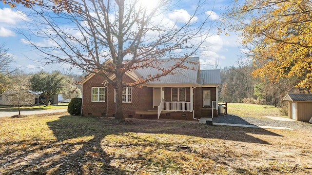 exterior space with a lawn, a shed, and covered porch