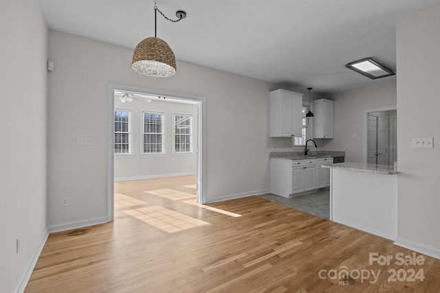 kitchen with pendant lighting, light wood-type flooring, white cabinetry, and ceiling fan