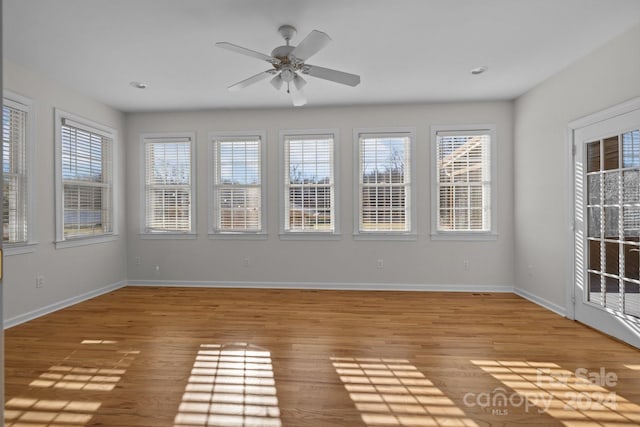 unfurnished sunroom with ceiling fan