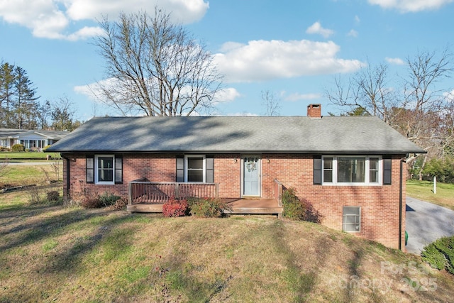 ranch-style home with a front yard and a wooden deck