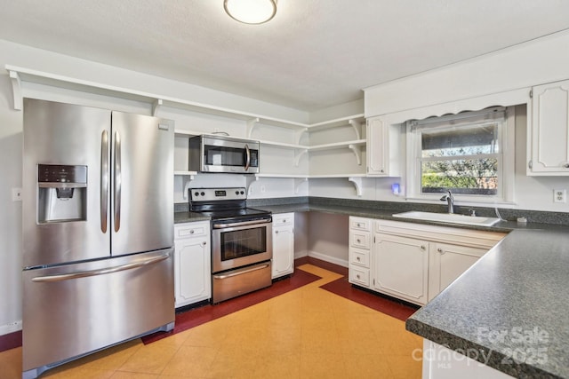 kitchen with sink, white cabinets, and appliances with stainless steel finishes