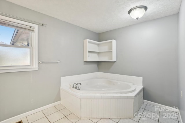 bathroom featuring a textured ceiling, tile patterned floors, and a bathtub