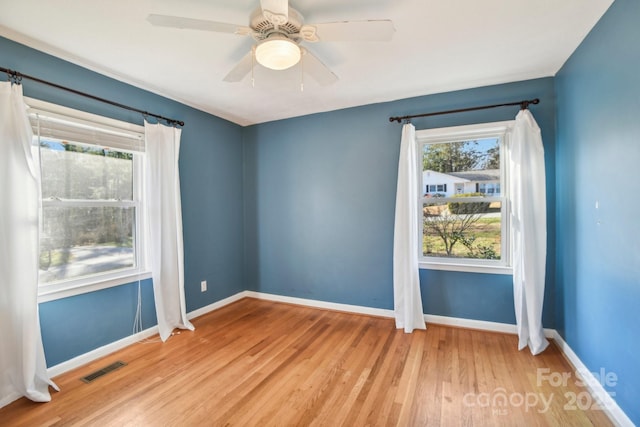 spare room featuring ceiling fan, plenty of natural light, and light hardwood / wood-style flooring