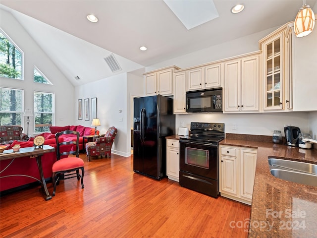 kitchen featuring black appliances, decorative light fixtures, a healthy amount of sunlight, and light wood-type flooring