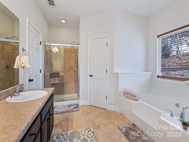 bathroom with tile patterned flooring, vanity, and plus walk in shower