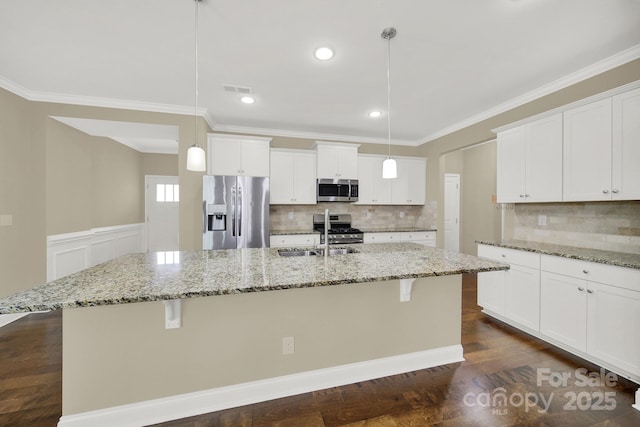 kitchen featuring pendant lighting, stainless steel appliances, and a center island with sink