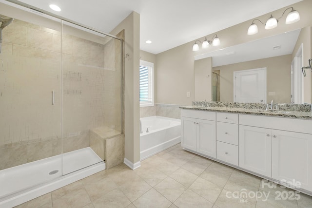 bathroom with tile patterned floors, vanity, and shower with separate bathtub