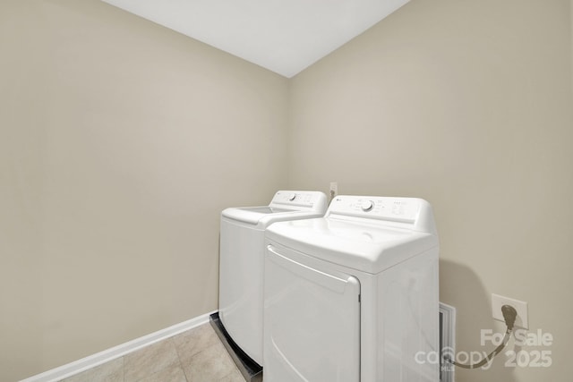 clothes washing area featuring washer and dryer and light tile patterned floors