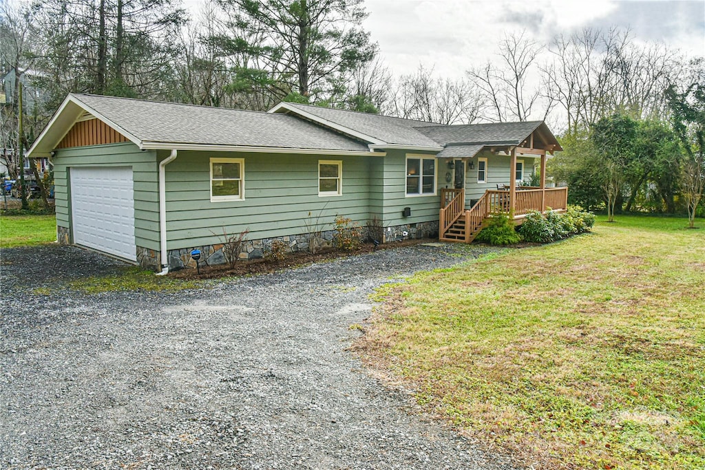 view of front of home featuring a front yard, a garage, and covered porch