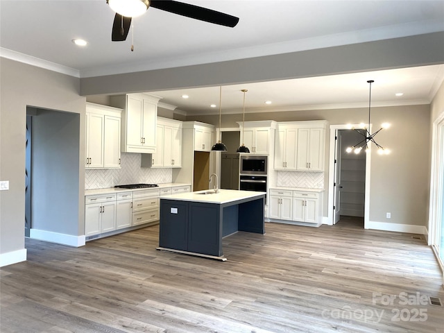 kitchen featuring appliances with stainless steel finishes, white cabinetry, ornamental molding, and light wood-style flooring