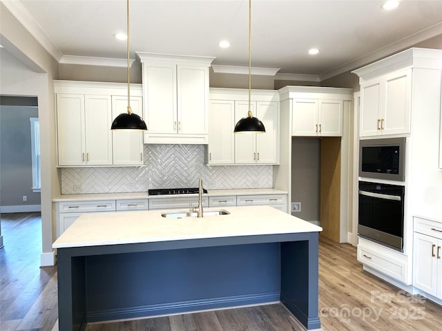 kitchen featuring wall oven, stainless steel microwave, light countertops, and a sink