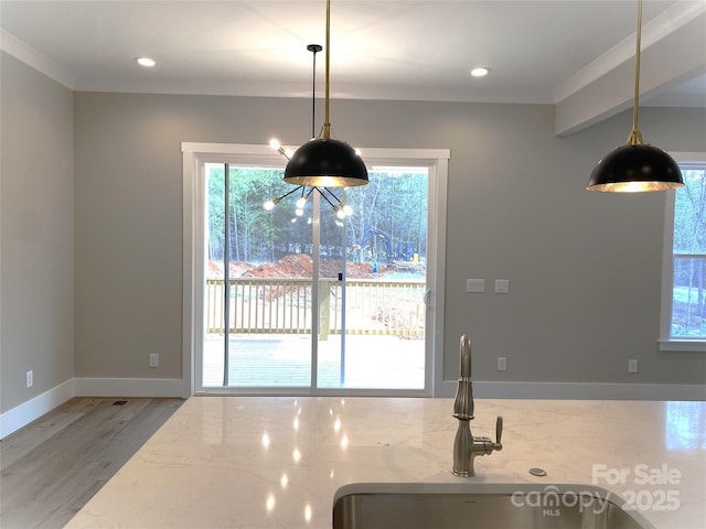 kitchen with light stone countertops, light wood finished floors, and a wealth of natural light