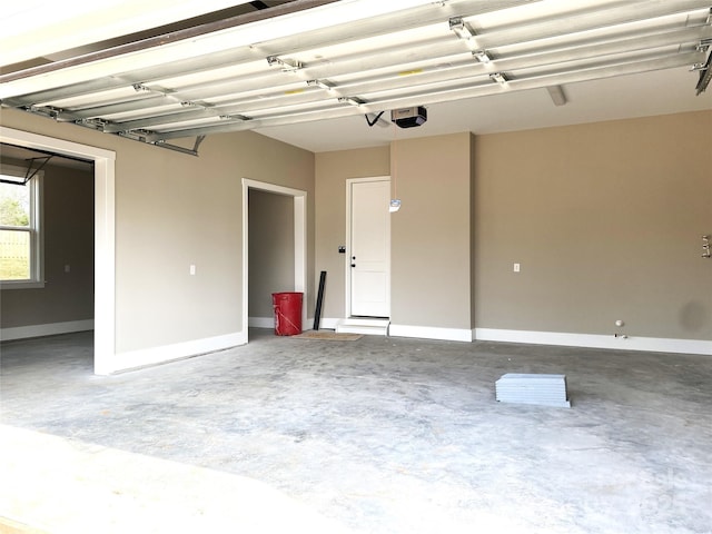 garage featuring a garage door opener and baseboards