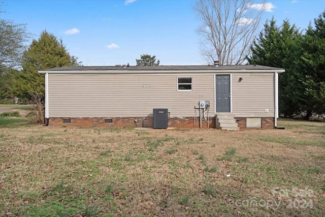 rear view of house with a yard and central air condition unit