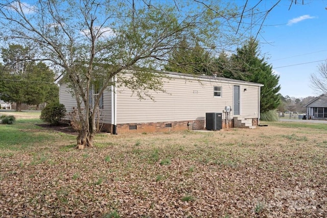 rear view of house with a lawn and central AC