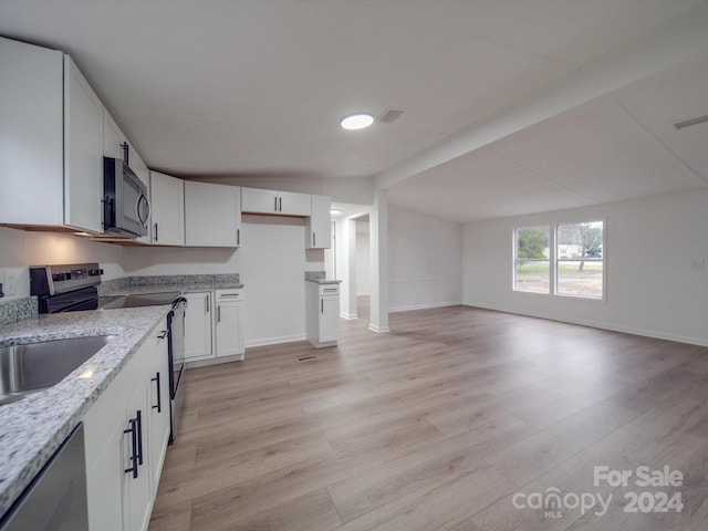 kitchen featuring white cabinets, light stone counters, appliances with stainless steel finishes, and light hardwood / wood-style flooring