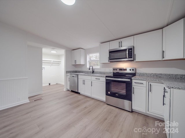 kitchen featuring white cabinetry, sink, light wood-type flooring, and appliances with stainless steel finishes