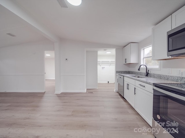 kitchen with white cabinets, vaulted ceiling with beams, sink, and appliances with stainless steel finishes