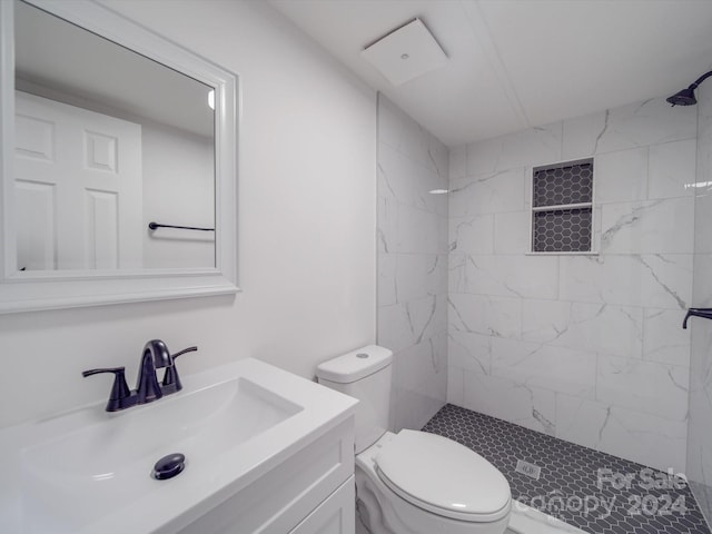 bathroom featuring vanity, toilet, and tiled shower