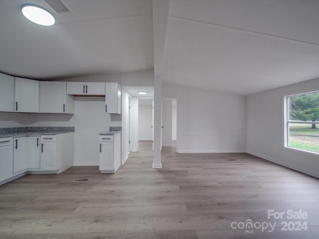 kitchen featuring white cabinetry, light hardwood / wood-style floors, and lofted ceiling