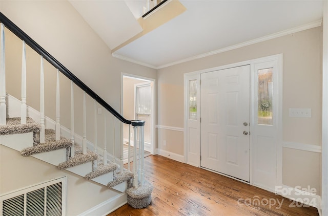 entrance foyer featuring wood-type flooring and crown molding