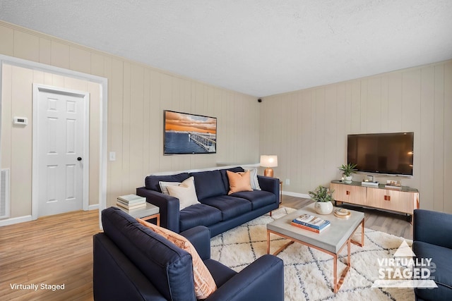 living room with a textured ceiling and hardwood / wood-style flooring