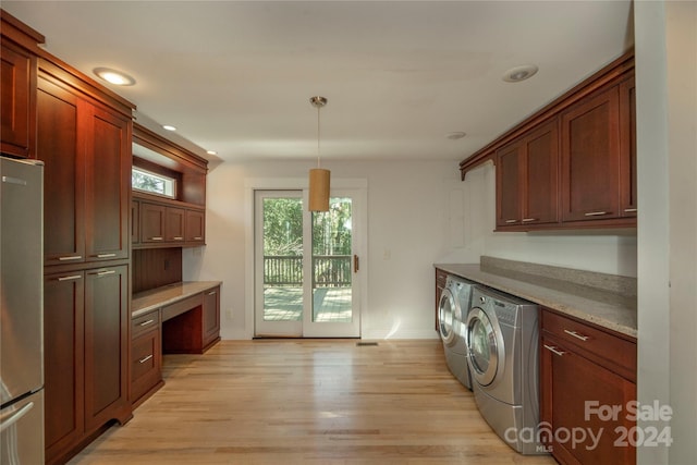 clothes washing area with cabinets, independent washer and dryer, and light hardwood / wood-style flooring