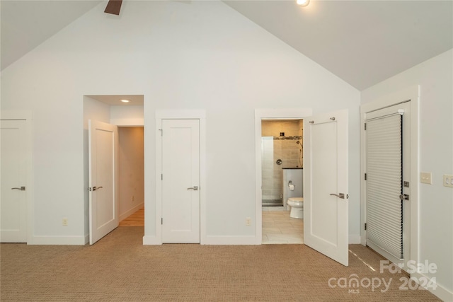 unfurnished bedroom featuring ensuite bathroom, high vaulted ceiling, ceiling fan, and light colored carpet