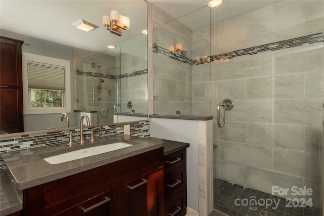 bathroom featuring backsplash, a shower with door, and vanity