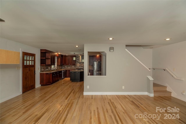 unfurnished living room with light wood-type flooring and sink