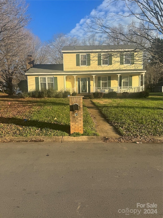 view of front of house with a front yard and a porch