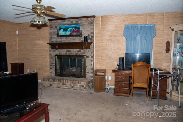 living room with ceiling fan, a fireplace, and a textured ceiling