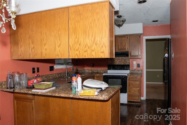 kitchen featuring range with electric stovetop, dark hardwood / wood-style flooring, exhaust hood, kitchen peninsula, and a textured ceiling