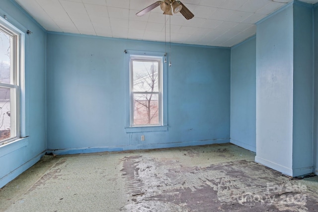 unfurnished room featuring plenty of natural light, ceiling fan, and ornamental molding