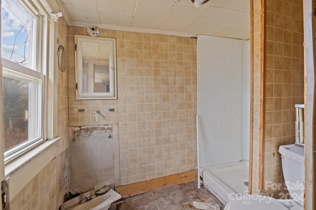 bathroom featuring crown molding, a shower, tile walls, tile patterned flooring, and toilet