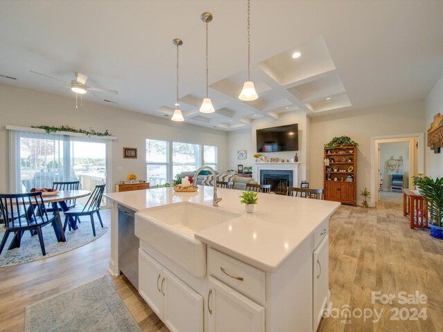 kitchen with light hardwood / wood-style floors, sink, a kitchen island with sink, and coffered ceiling