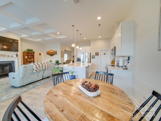 dining area with beam ceiling and coffered ceiling