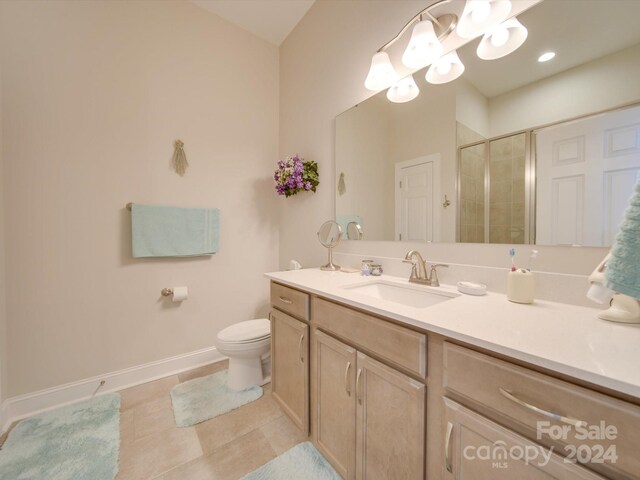 bathroom with toilet, tile patterned flooring, vanity, and walk in shower