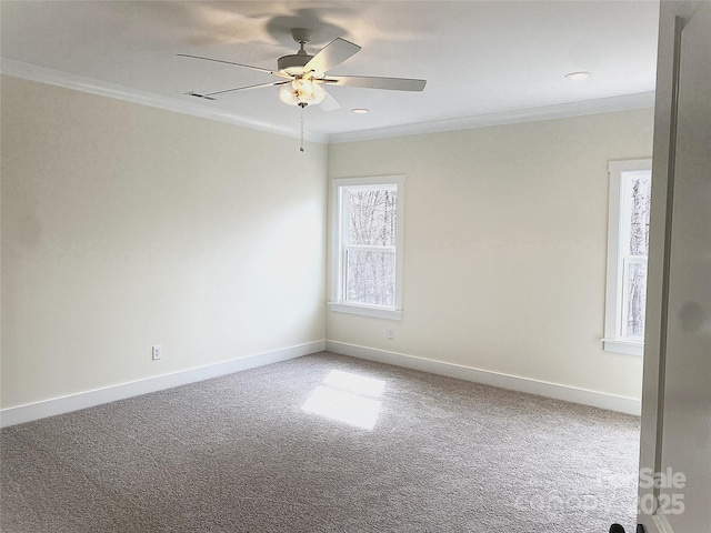 carpeted spare room with baseboards, visible vents, ornamental molding, and ceiling fan