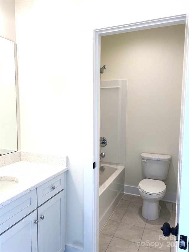 bathroom featuring baseboards, toilet, tile patterned flooring, vanity, and shower / washtub combination