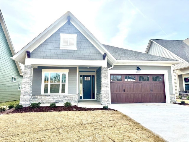 craftsman inspired home with a garage and a front lawn