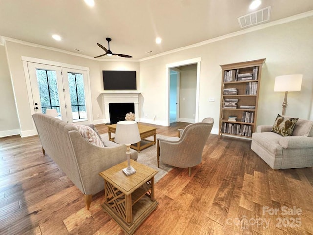 living room featuring ceiling fan, hardwood / wood-style floors, and crown molding