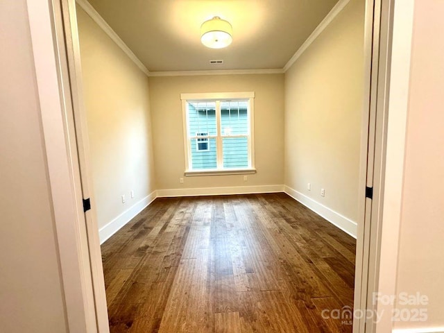 spare room featuring crown molding and dark wood-type flooring