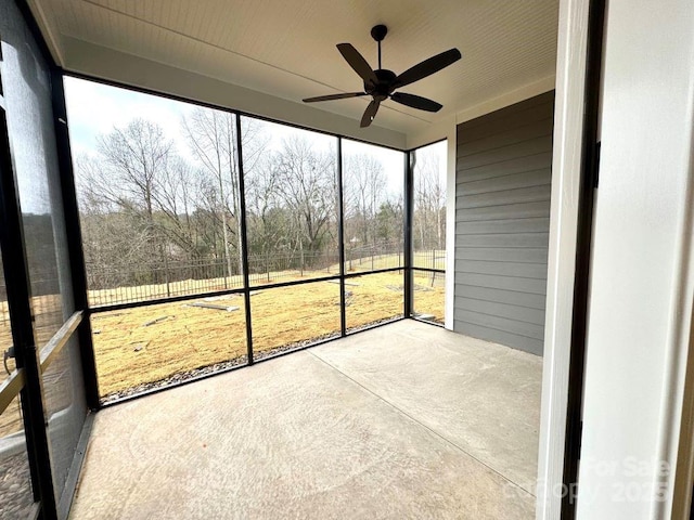 unfurnished sunroom with ceiling fan