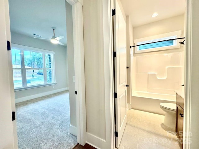 bathroom with shower / tub combination, ceiling fan, and toilet