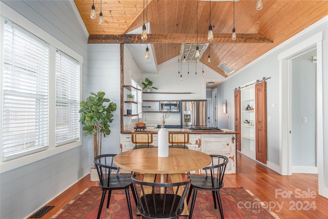 dining area featuring hardwood / wood-style floors, vaulted ceiling with beams, a barn door, and wooden ceiling