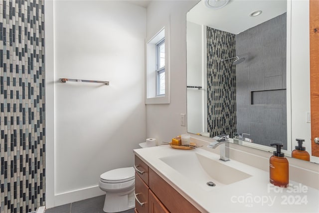 bathroom featuring vanity, toilet, and tiled shower